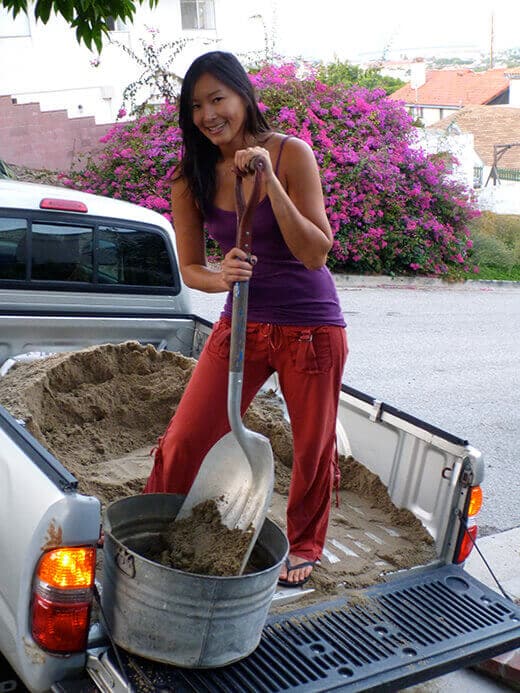 The Nuts and Bolts of the Tiki Coop Shoveling sand for the chicken coop