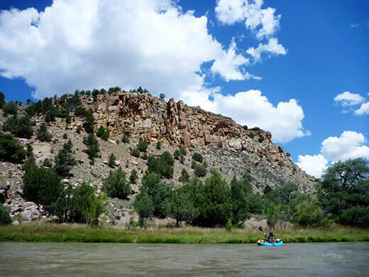 Kayak Camping on the Rio Chama Paddling past desert brush and rocky slopes on the Rio Chama