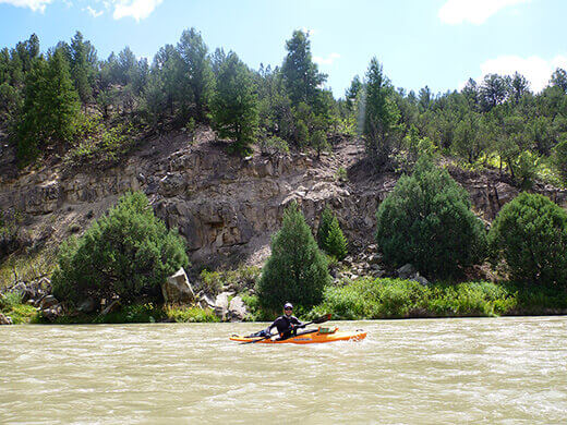 Kayak Camping on the Rio Chama Paddling past desert brush and rocky slopes on the Rio Chama