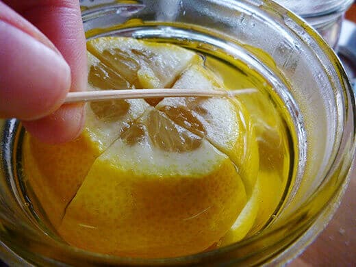 Wedge a 3-inch toothpick into the neck of the jar to keep lemons submerged