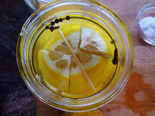 Wedge a 3-inch toothpick into the neck of the jar to keep lemons submerged
