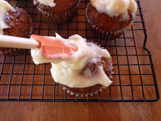 Spread cream cheese frosting on muffins