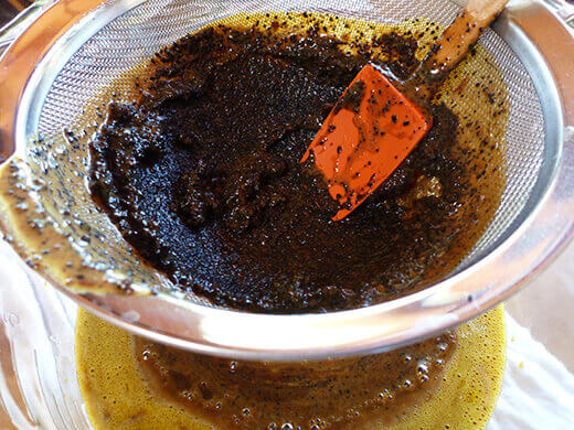 Strain every last bit of coffee by pressing on the grounds with a spoon