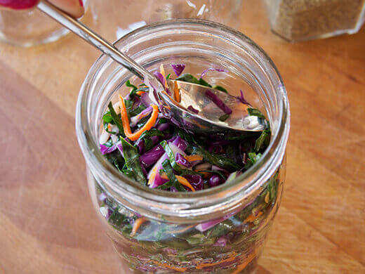 Tamp the cabbage and carrots down to release more liquid