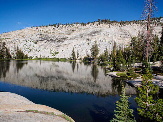 Granite wall reflecting on the lake