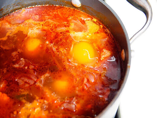 Crack eggs into the pot and cook until the whites are set