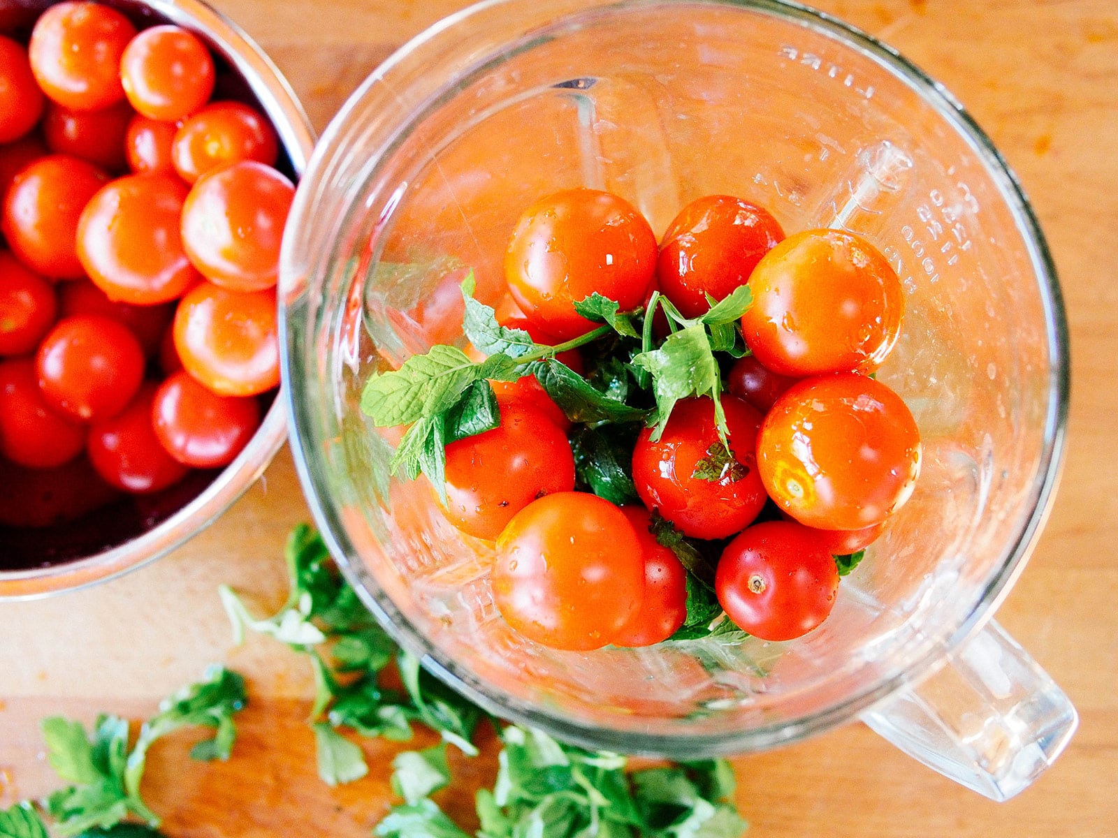 Add tomatoes, parsley, mint, garlic, and olive oil to a blender