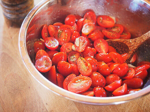 Toss tomato halves with olive oil, garlic, salt, and pepper