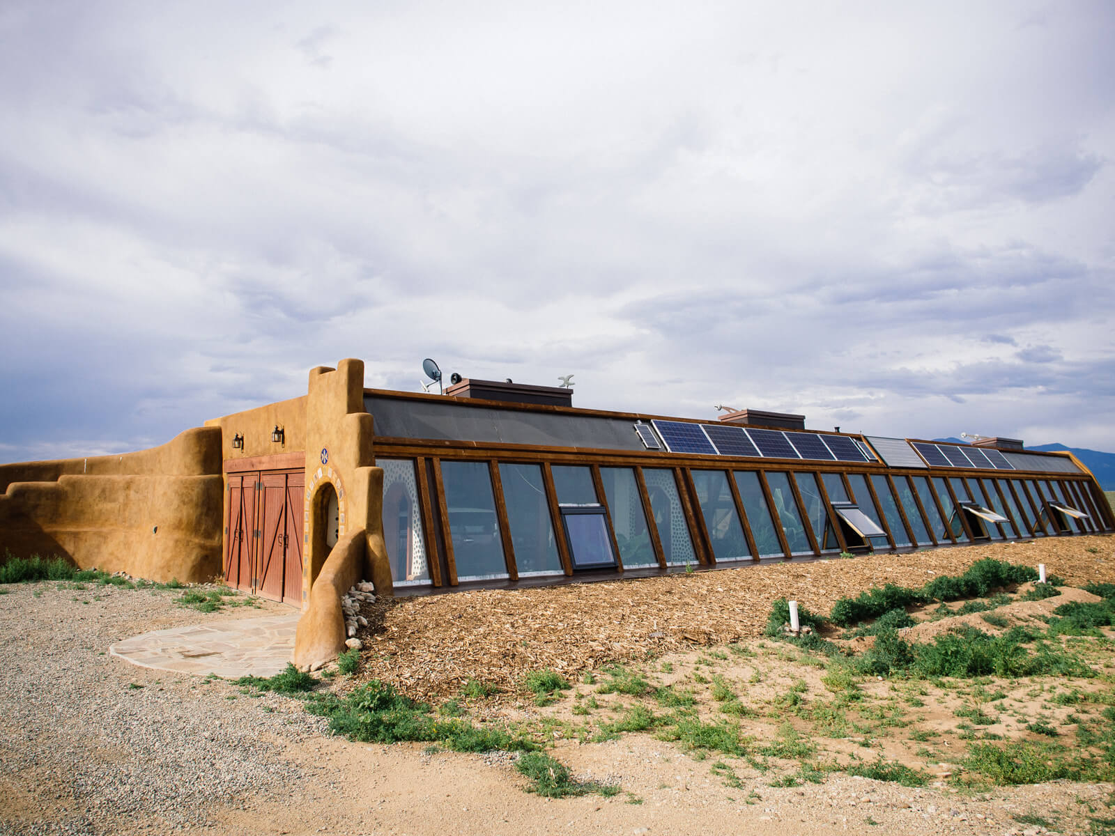 A passive solar Earthship home in the Greater World Earthship Community in Taos