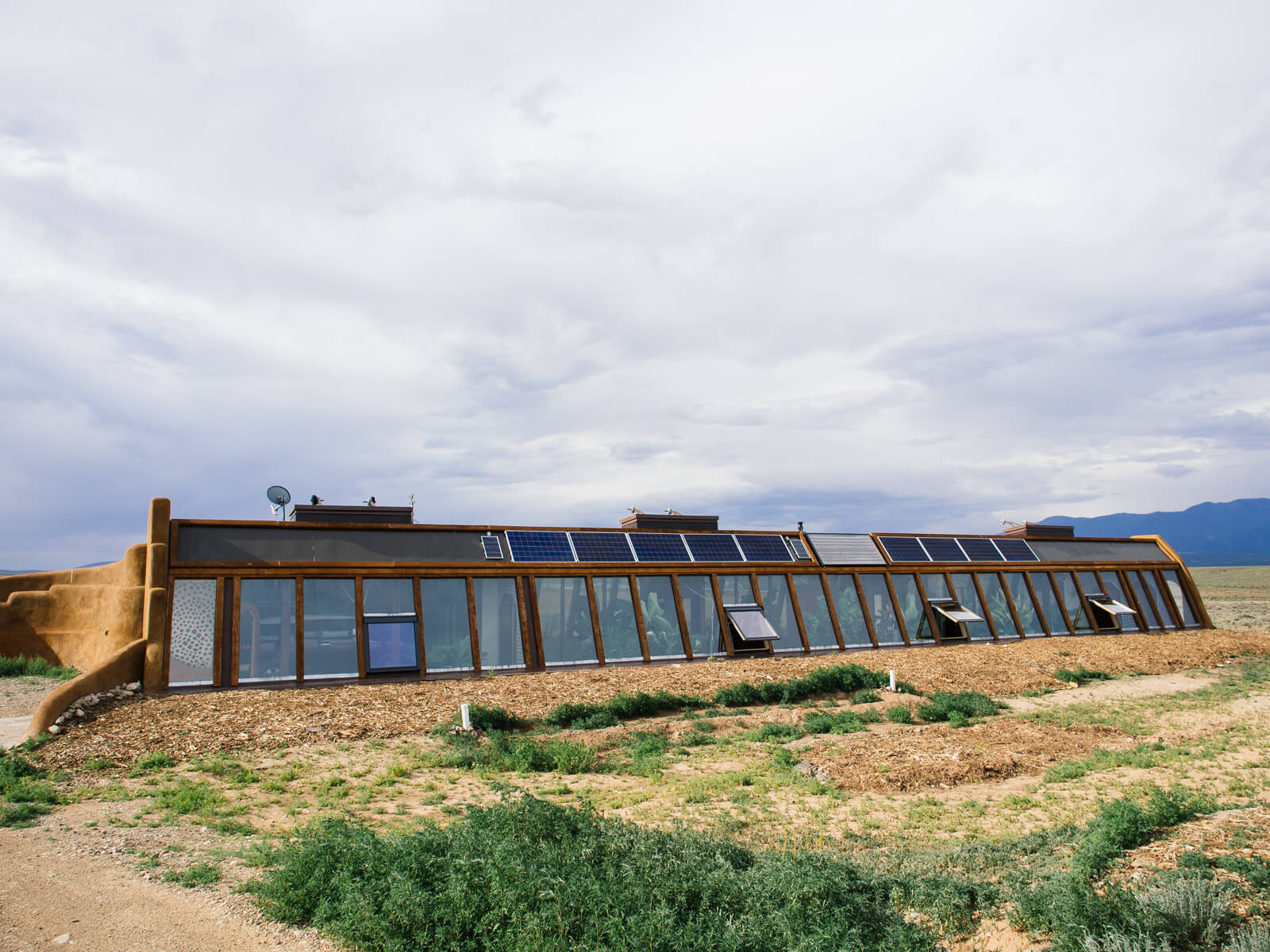 A long bank of south-facing windows in a Global Model Earthship house