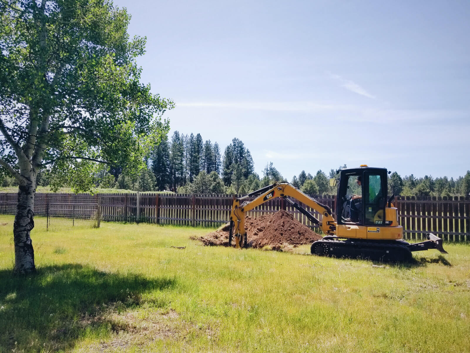 Excavator digging septic test holes on our property