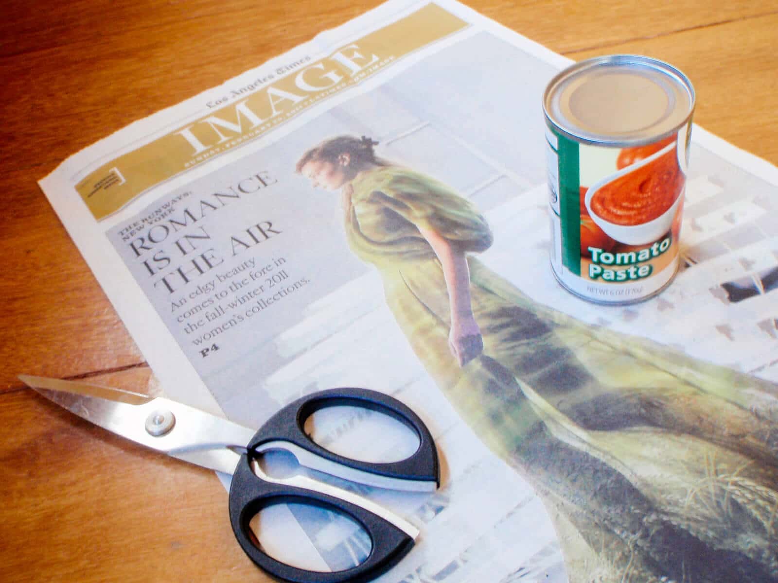 Gather a stack of newspaper, scissors, and a can of tomato paste to make your newspaper seed pots