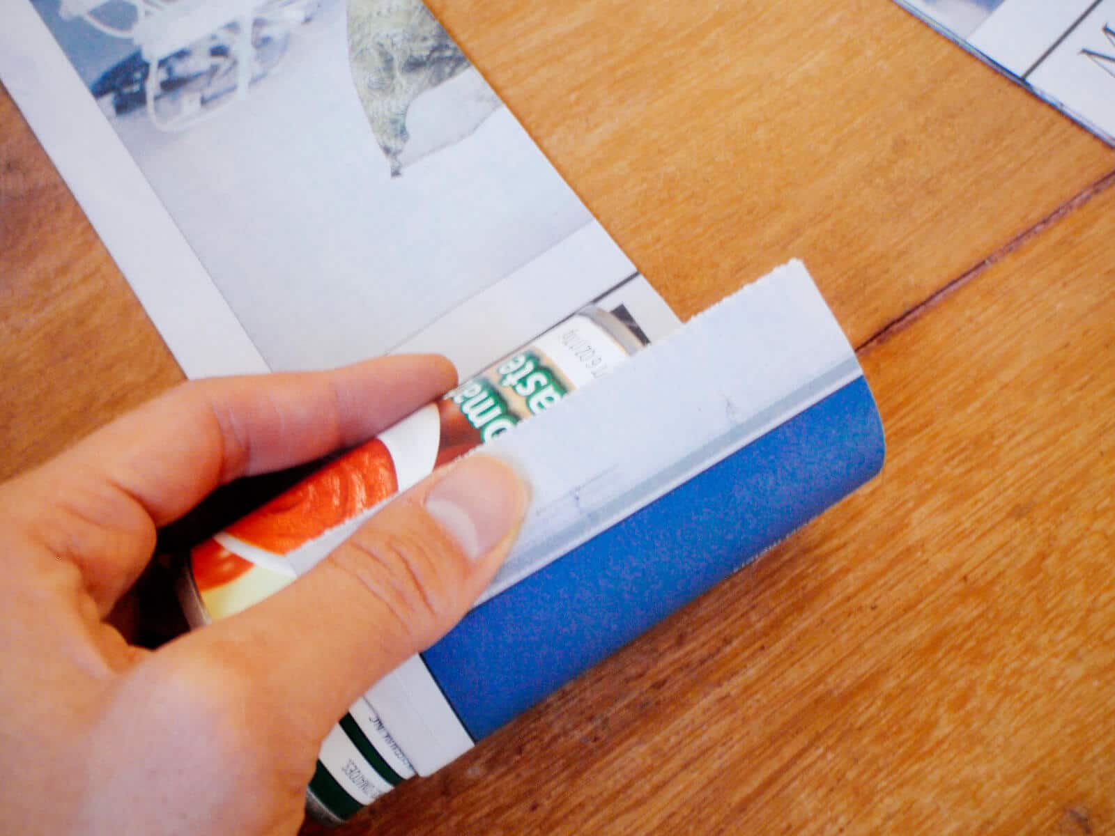 Roll the can along the newspaper away from you until it's wrapped all the way around