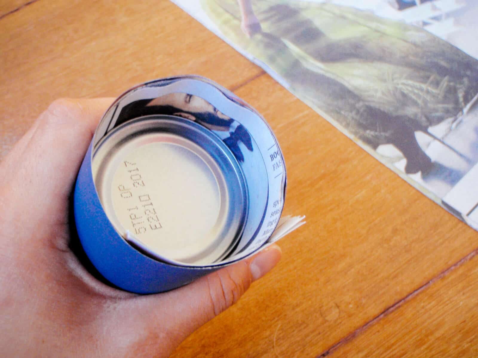Make the bottom by folding the newspaper edge down over the can
