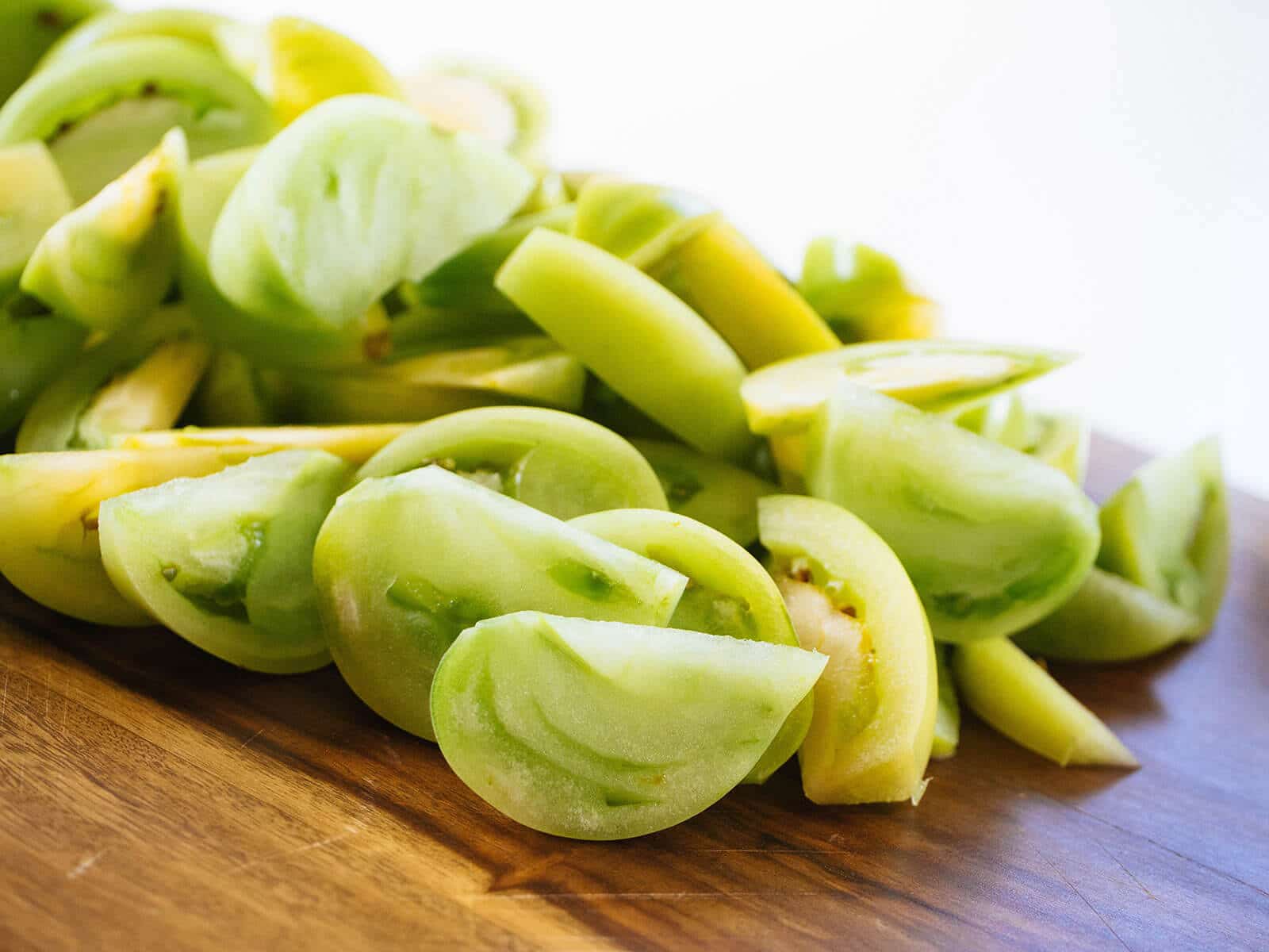 Sliced green tomatoes on a cutting board