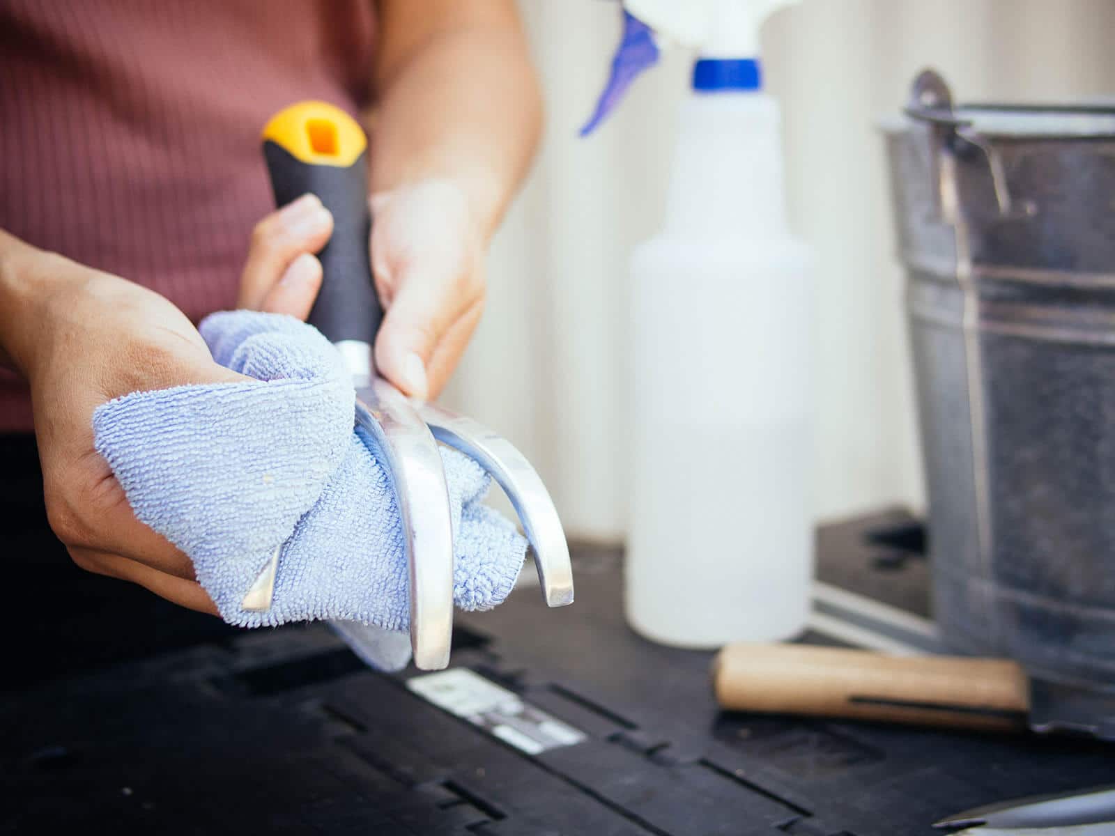 Hand wiping down a hand cultivator with a clean rag