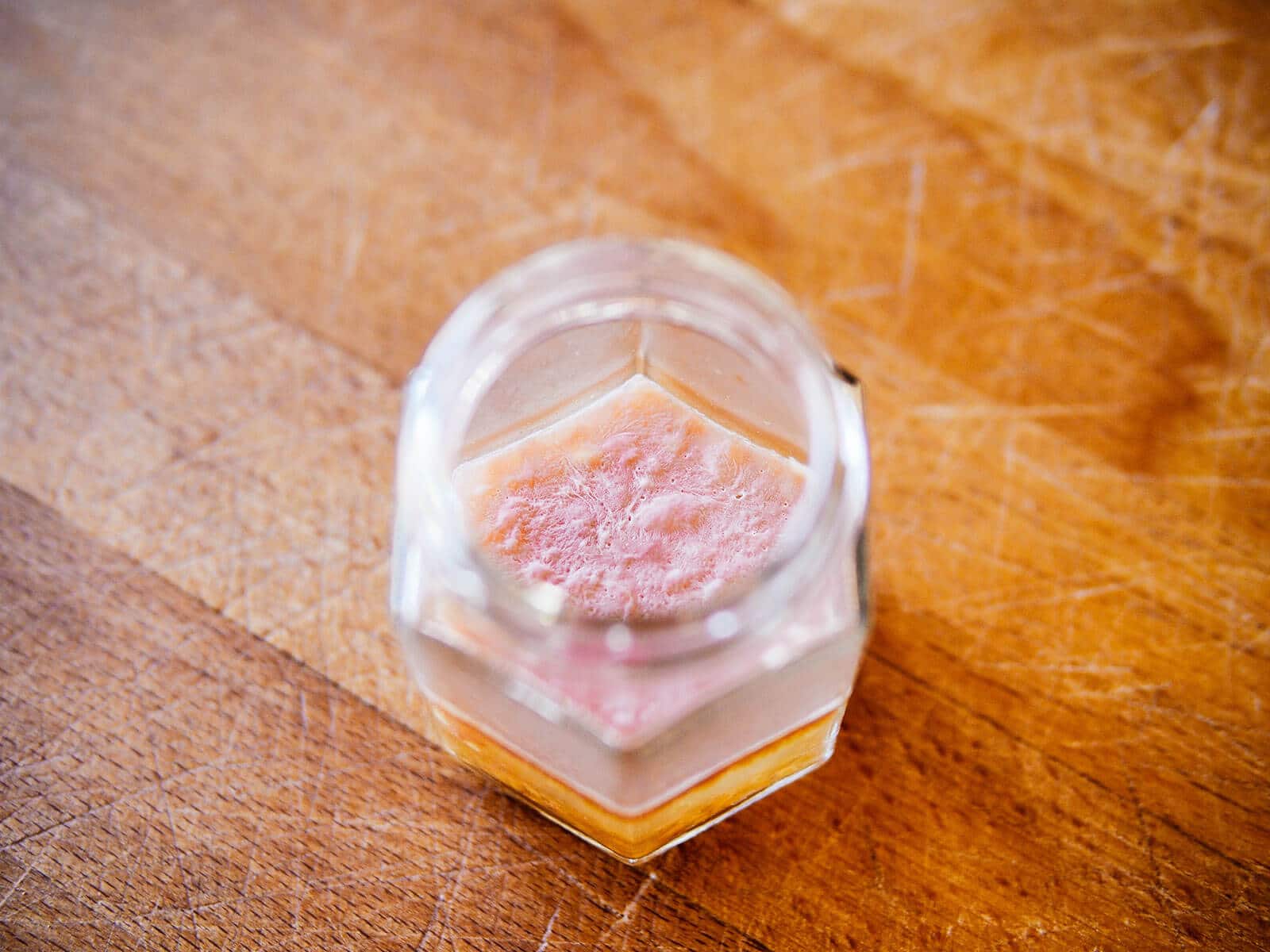 A layer of kahm yeast covering the surface of the water in a jar