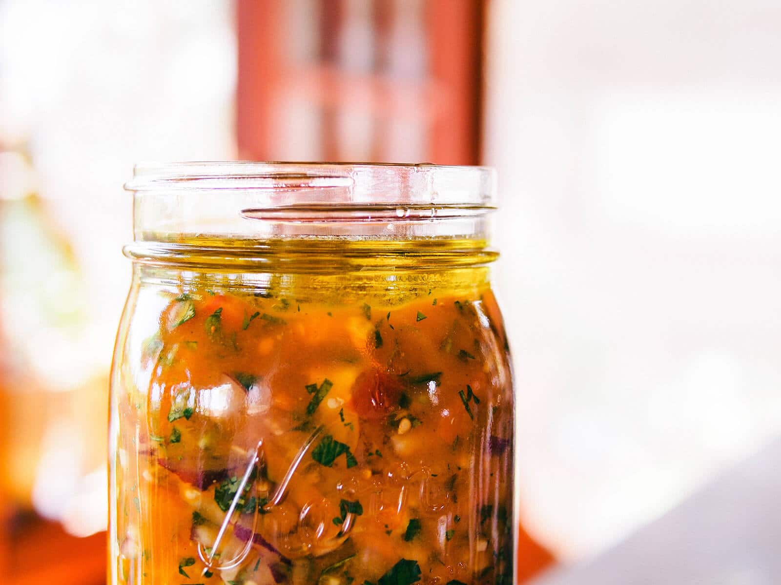 Close-up of olive oil layer in a jar of fermented salsa