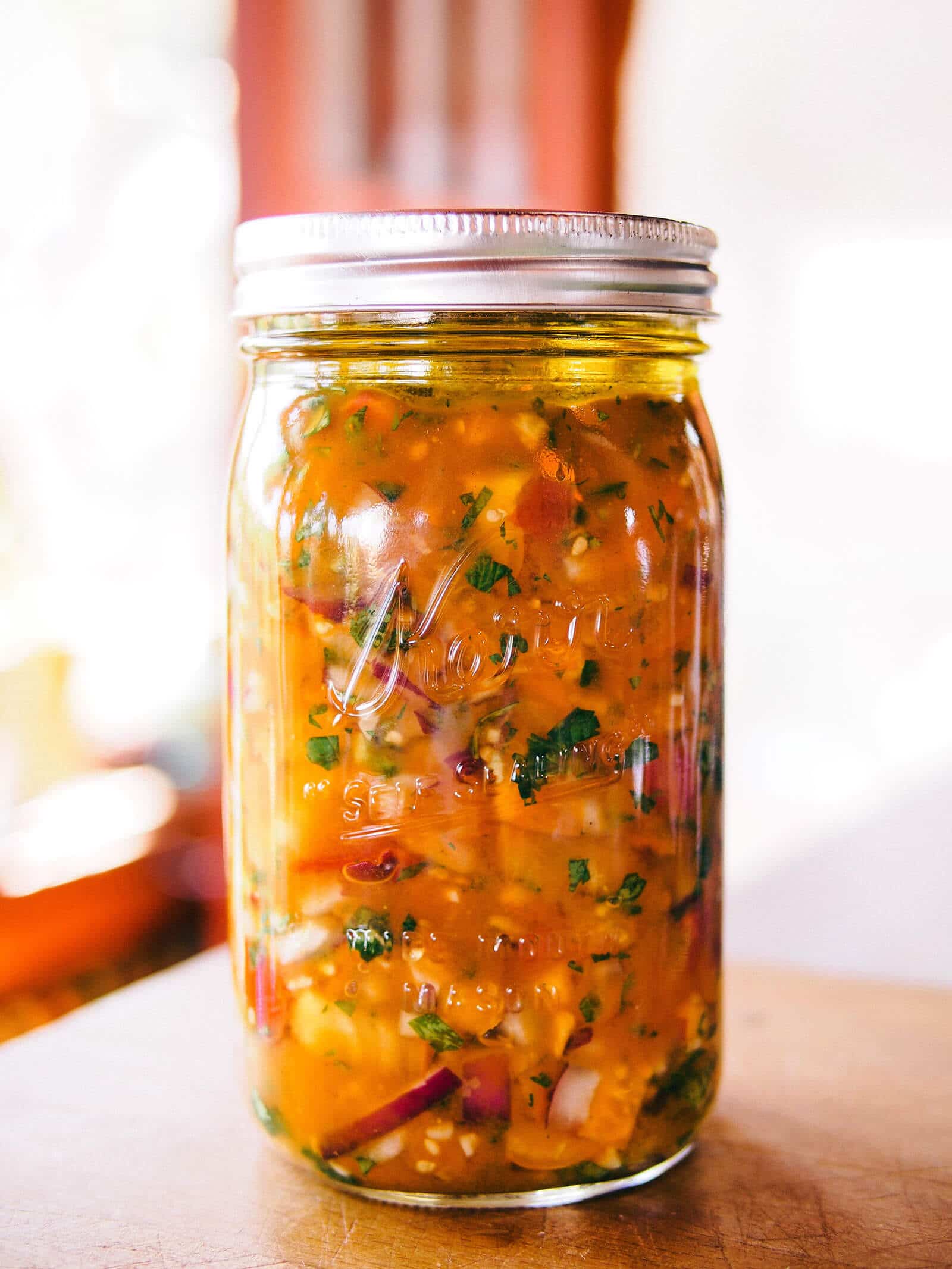 Jar of fermented salsa on a kitchen counter
