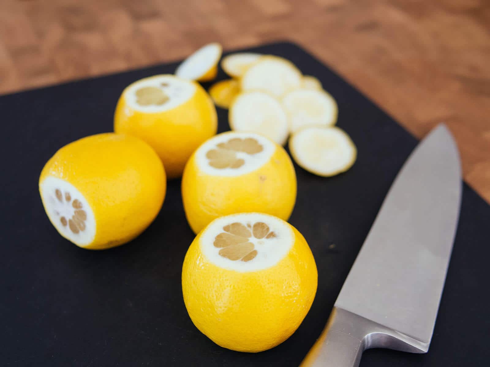 Lemons on a cutting board with their tops and bottoms sliced off