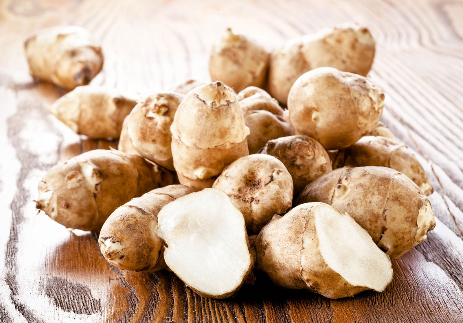 Pile of Jerusalem artichokes on a wooden surface